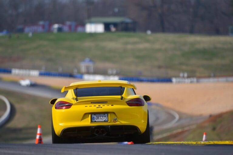 yellow race car porsche on track