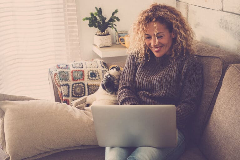 Woman with dog working on laptop