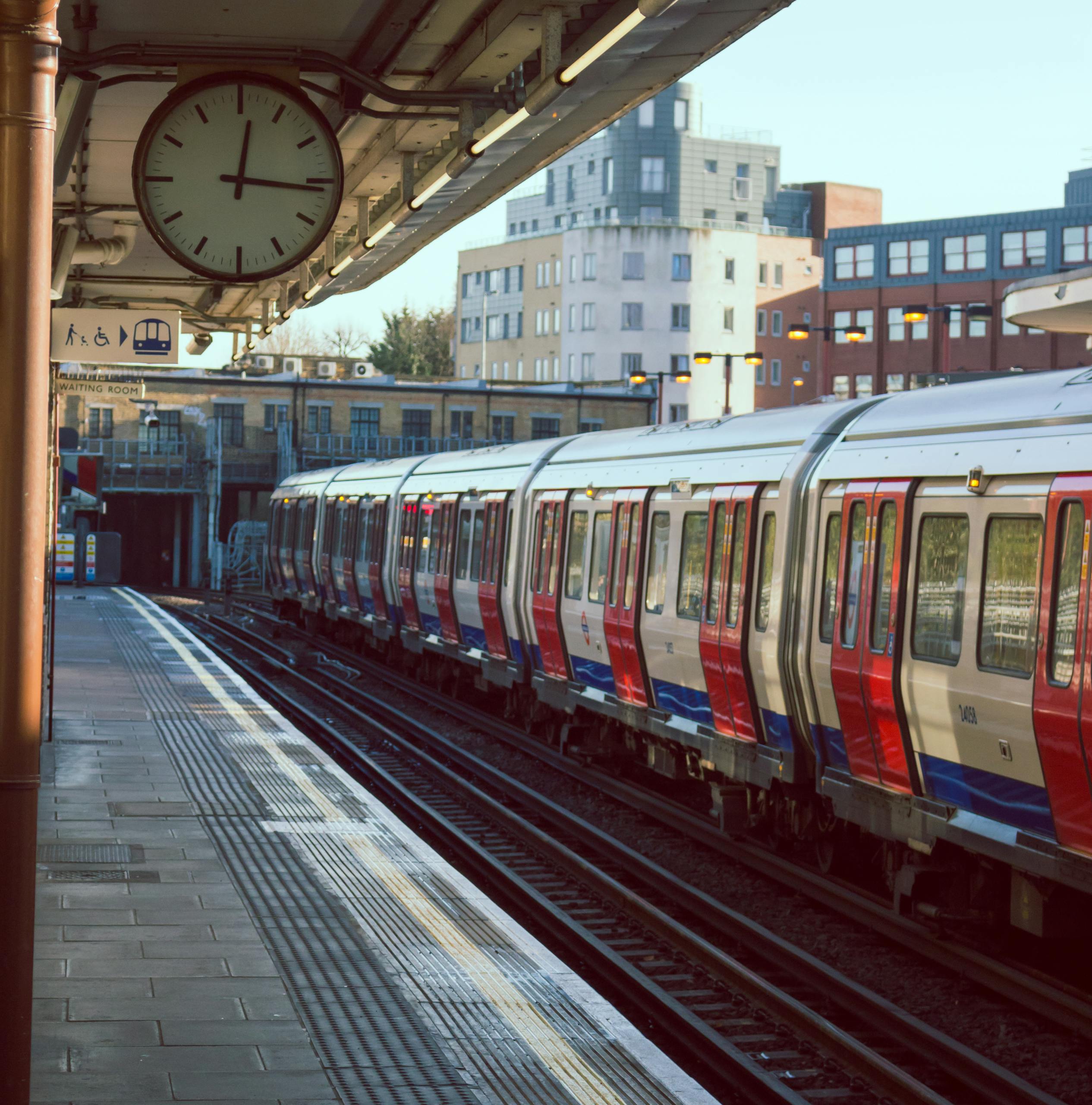 A city train station with a train on the tracks during sunrise. Ideal for urban and transportation themes.